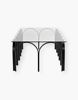 Table with rectangular industrial steel tubing finished in black and is fashioned into a repeating horseshoe arch design and a simple glass top.