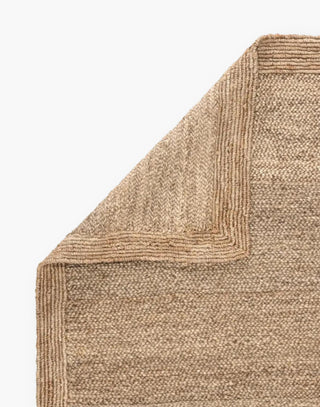 Jute rug with a rectangular border that frames the woven horizontal weave with a neutral colorway.