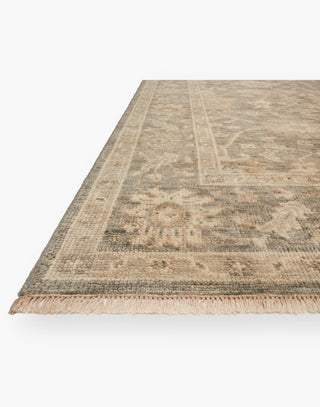 Wool rug with end-only fringed edging with hues of silver and ivory is made by artisans using traditional hand-knotting techniques.