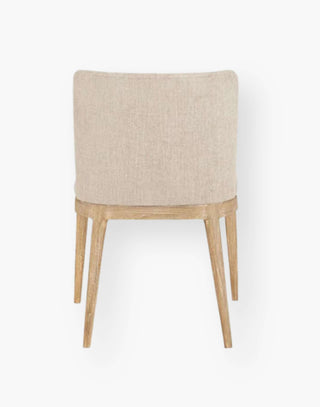 Dining chair with light wooden legs and cream colored upholstery.