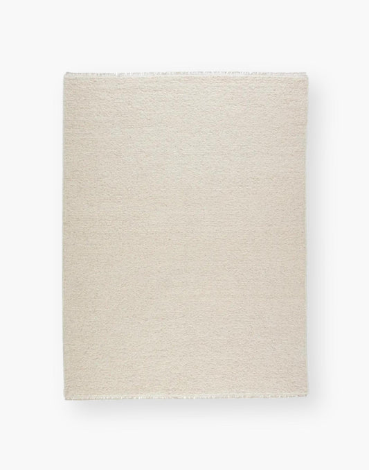 Wool rug with a light neutral cream palette and soft, textural soumak weave details.