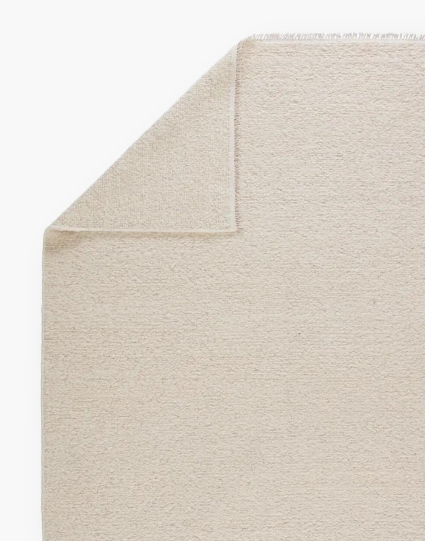 Wool rug with a light neutral cream palette and soft, textural soumak weave details.