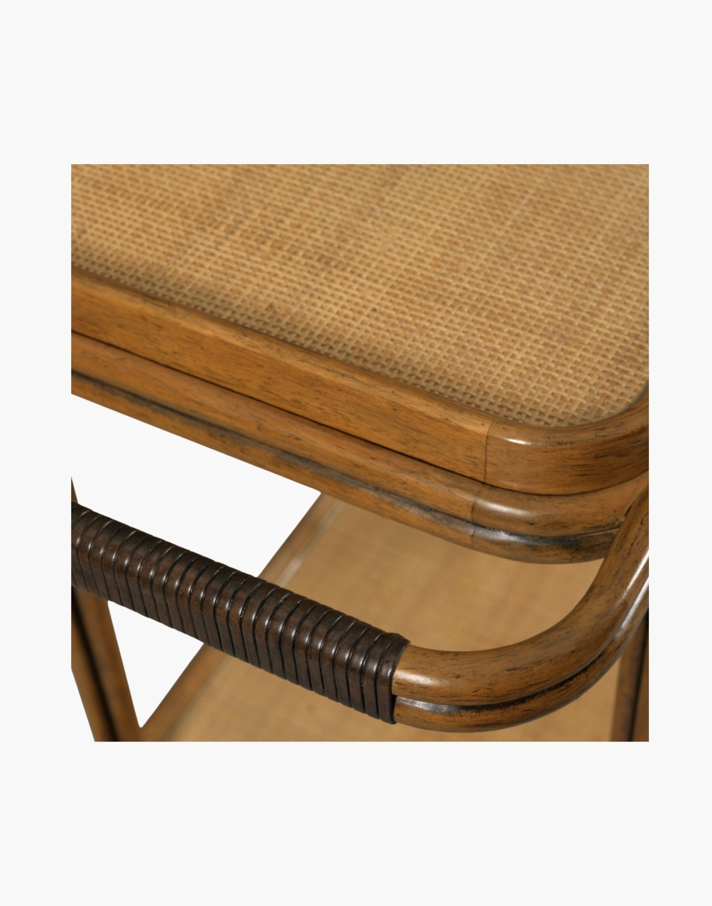 Bar cart with woven cane frame, tempered glass shelves, bottle holder, and brass casters in hazelnut finish.