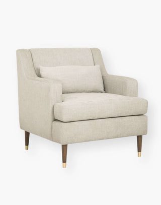 Tailored chair with recessed arms and a slightly reclined back with brass capped legs.