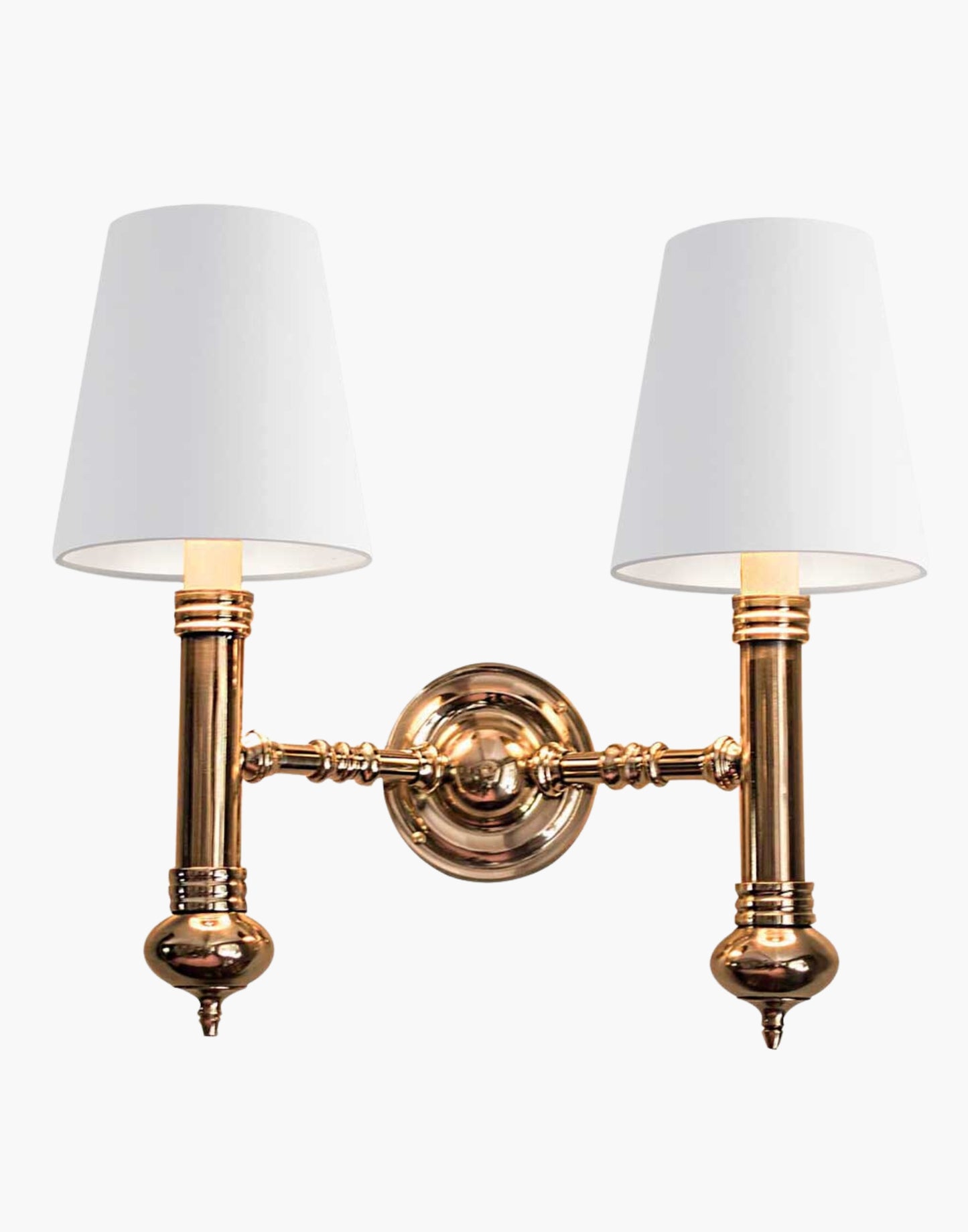 Elegant Carlton Twin Wall Sconce in cast brass with classic period design, featuring two light fixtures with ivory or black lampshades for balanced, warm illumination in vintage-inspired decor.