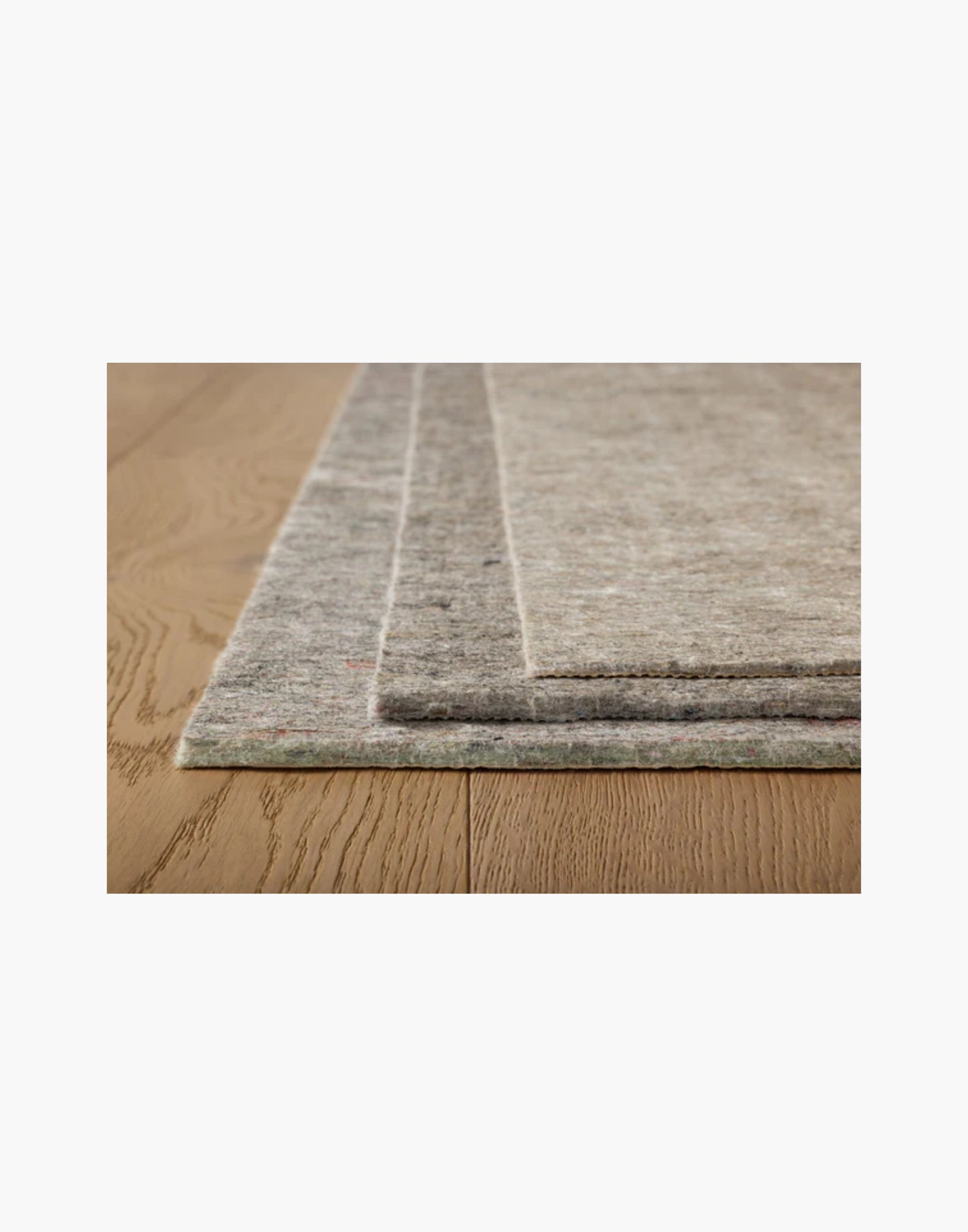 Grey non-slip rug pad with rubber backing, 100% recycled fibers, fits rugs on hard floors and carpet