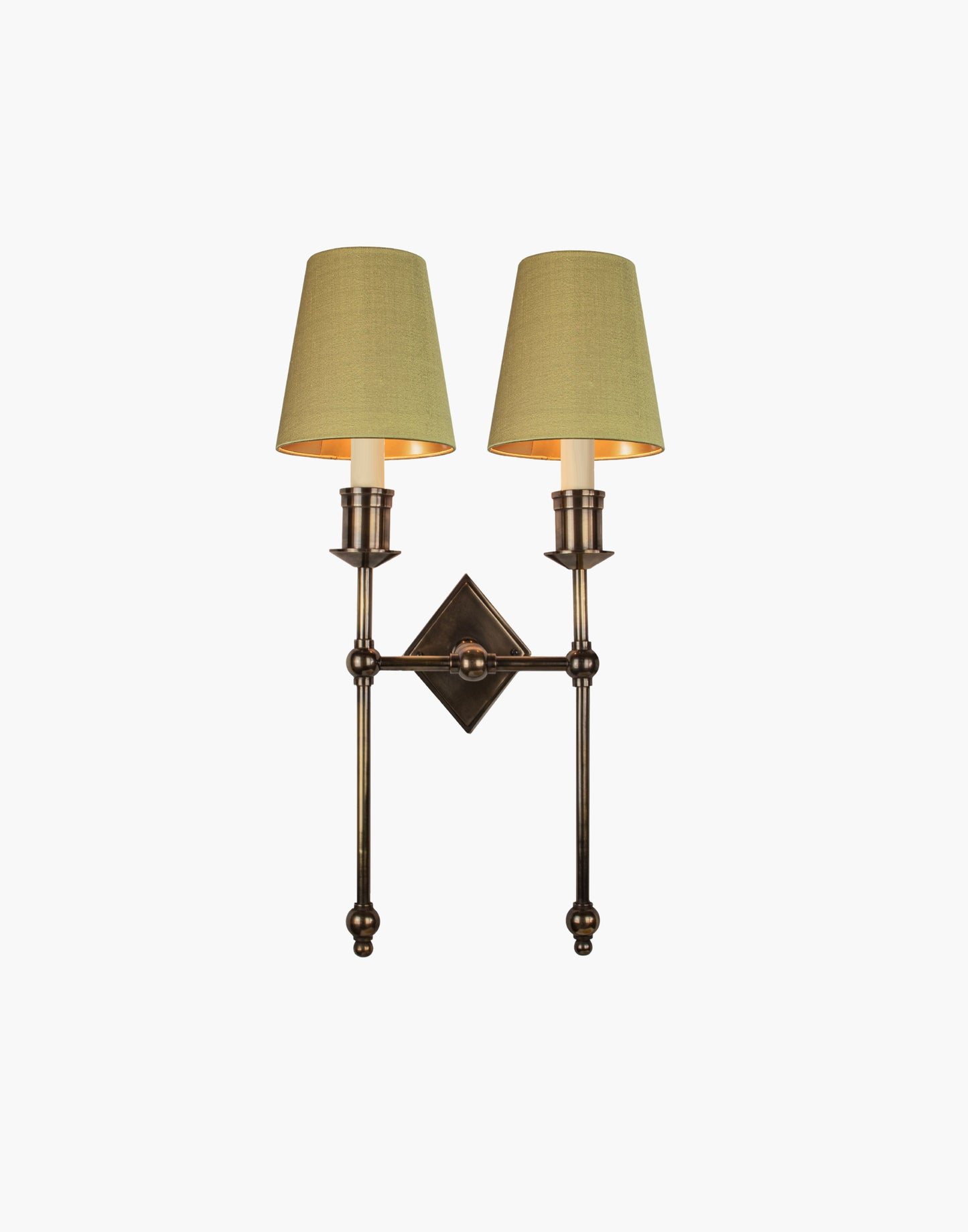 Wall sconce in cast and machined brass with diamond-shaped scalloped backplate and twin candle arms.