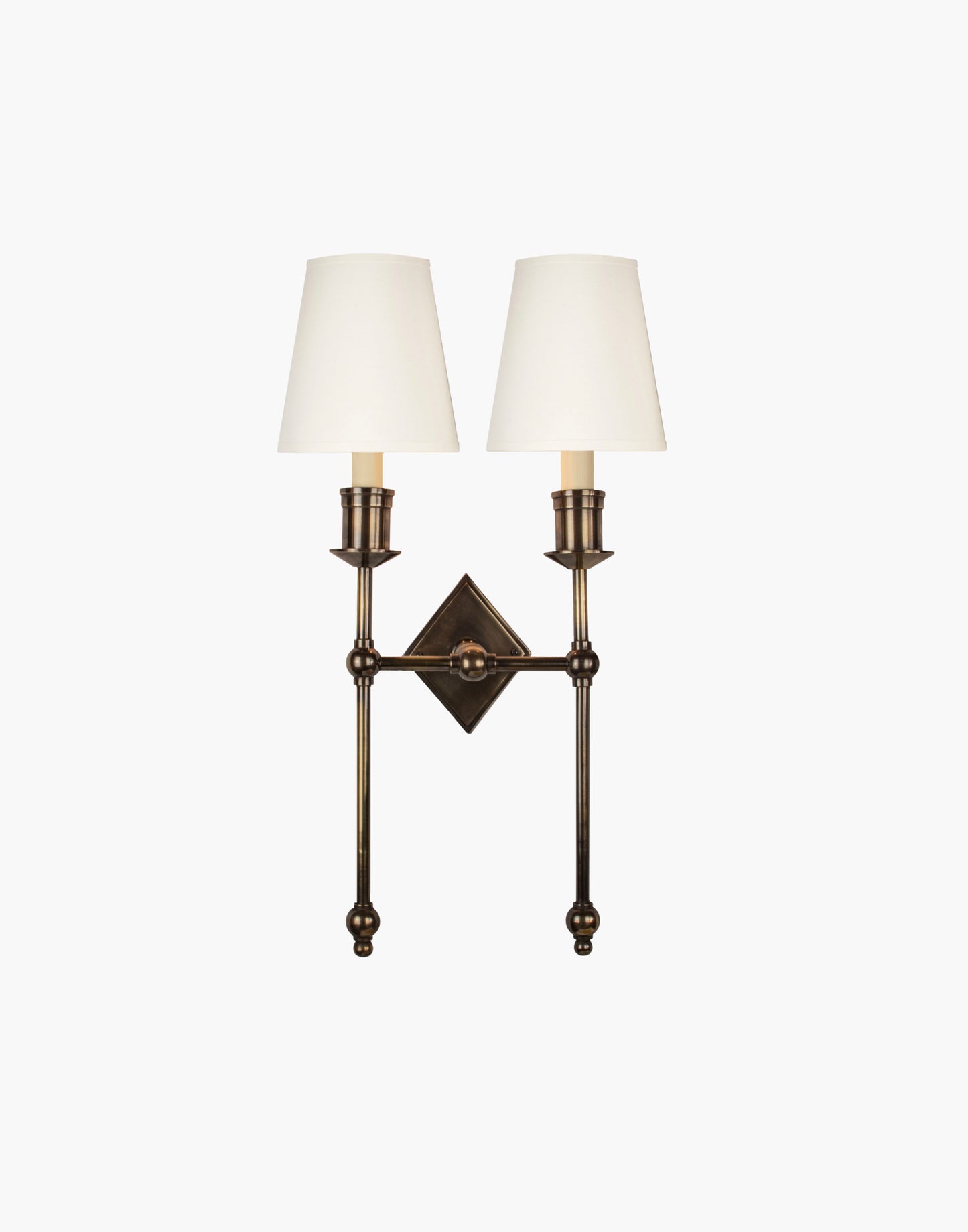 Wall sconce in cast and machined brass with diamond-shaped scalloped backplate and twin candle arms.
