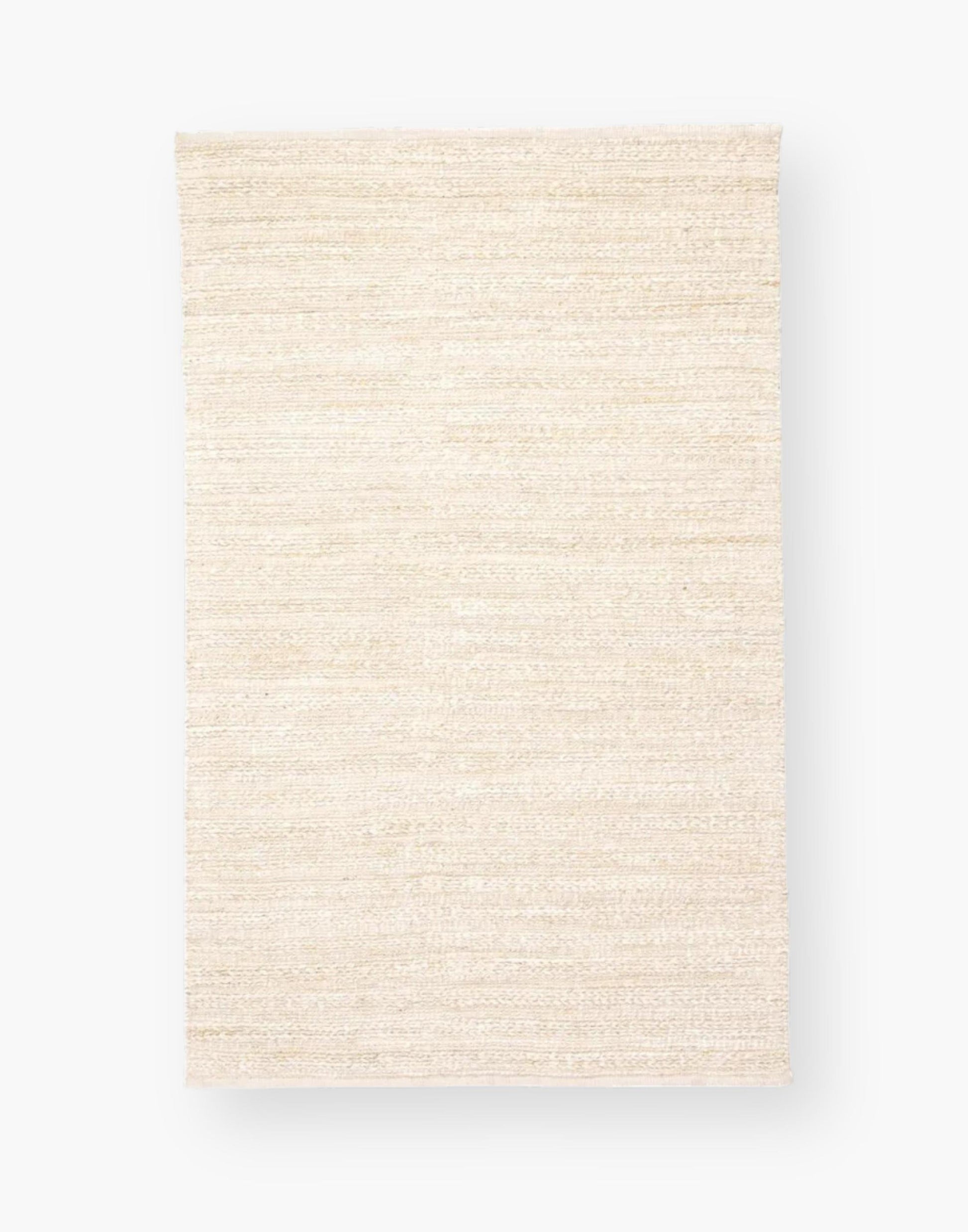 Jute area rug with cotton backing and a rayon blend with creamy natural and bleached white colorway.