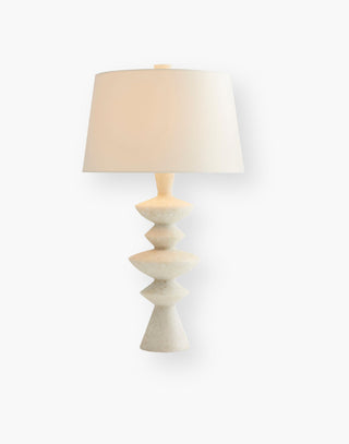 White Glass Stone table lamp with a formation of asymmetrical discs and an ivory cotton lined microfiber shade.