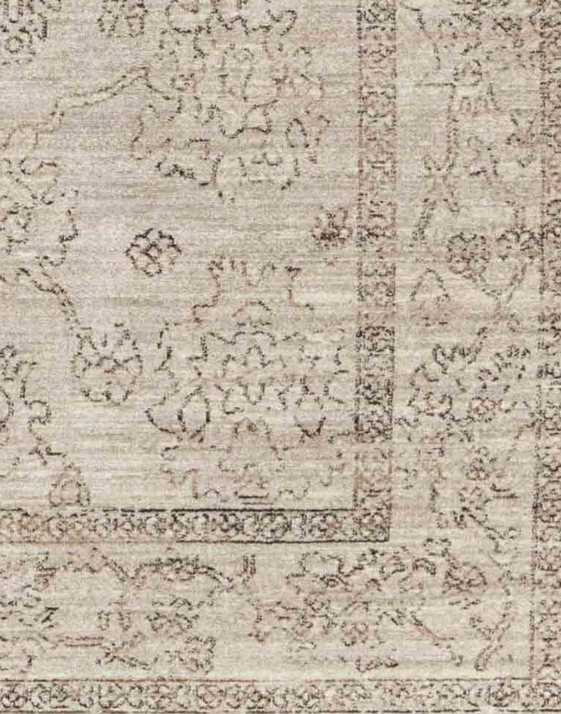 Polyester area rug that features a distressed, floral design in warm tones of brown, gray, taupe, and cream.