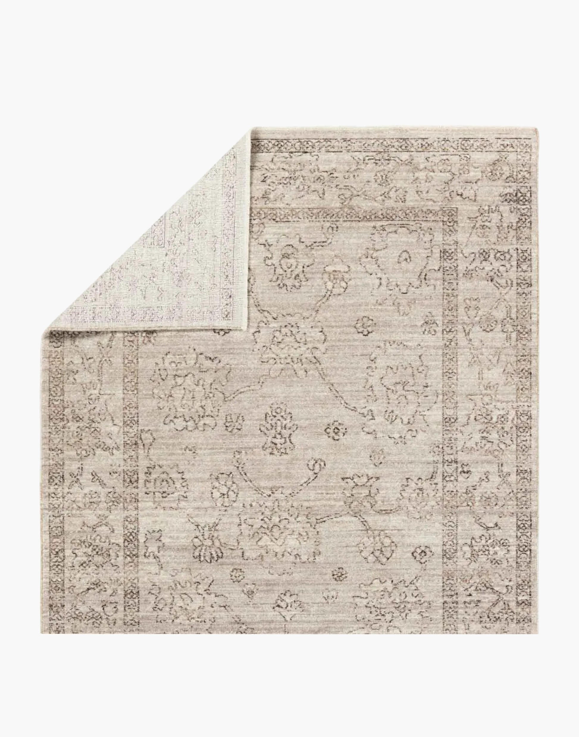 Polyester area rug that features a distressed, floral design in warm tones of brown, gray, taupe, and cream.