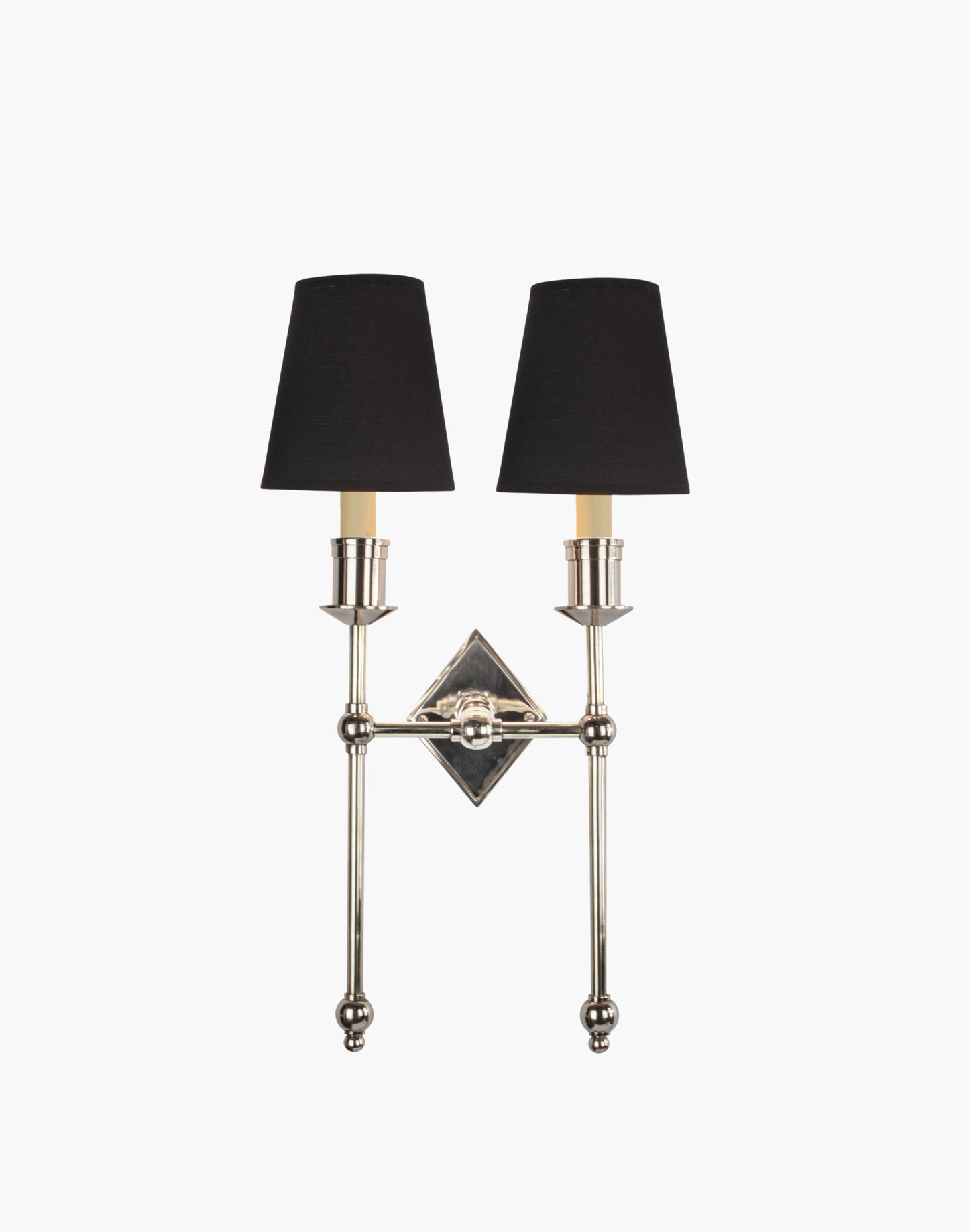 Wall sconce in cast and machined brass with diamond-shaped scalloped backplate and twin candle arms.