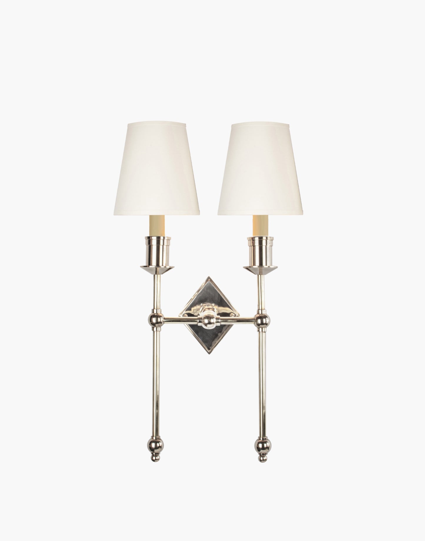 Wall sconce in cast and machined brass with diamond-shaped scalloped backplate and twin candle arms.
