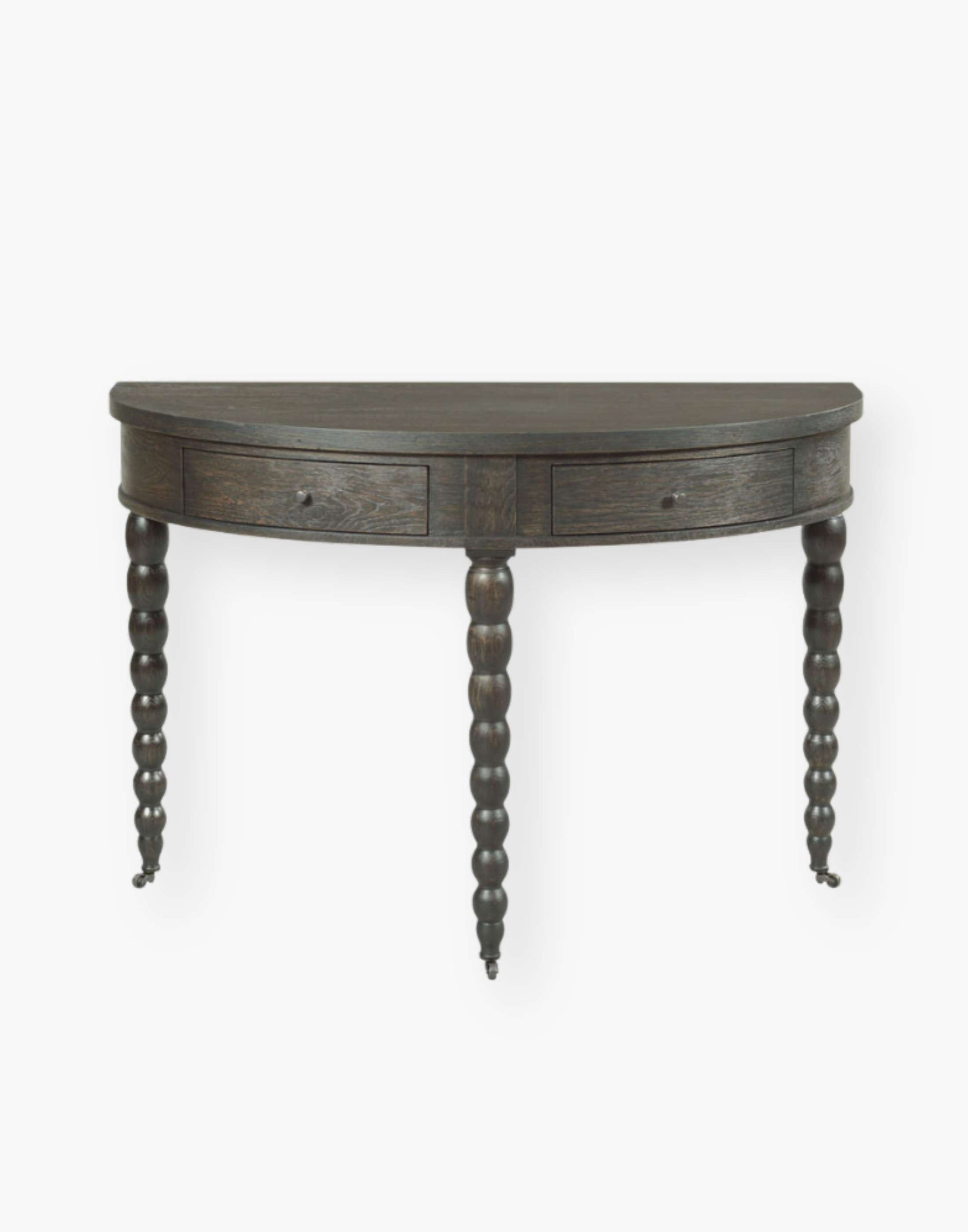 apron rail table fitted with two storage drawers that are mounted with turned brass knobs and raised by spool legs in worn black finish