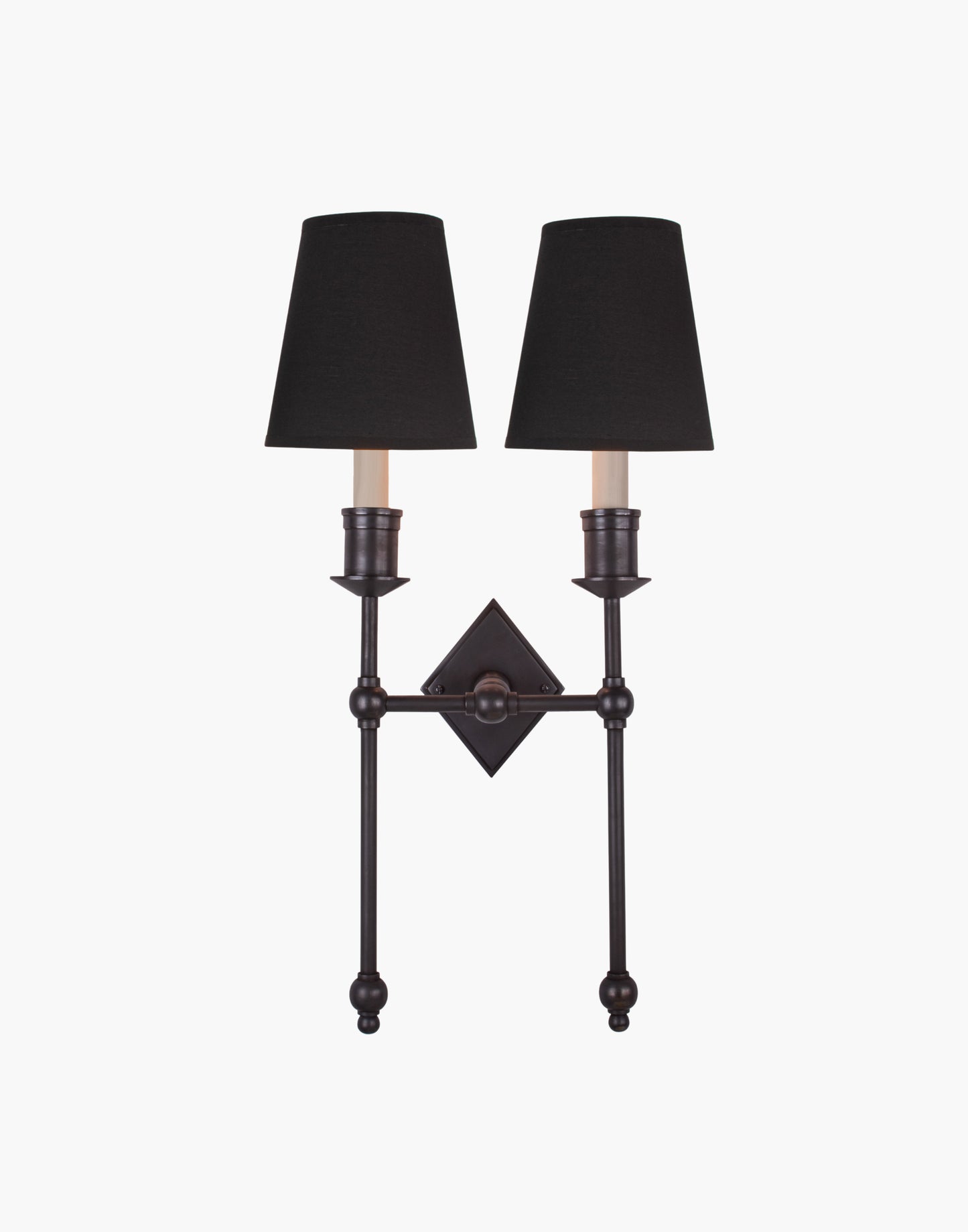 Wall sconce in cast and machined brass with diamond-shaped scalloped backplate and twin candle arms.