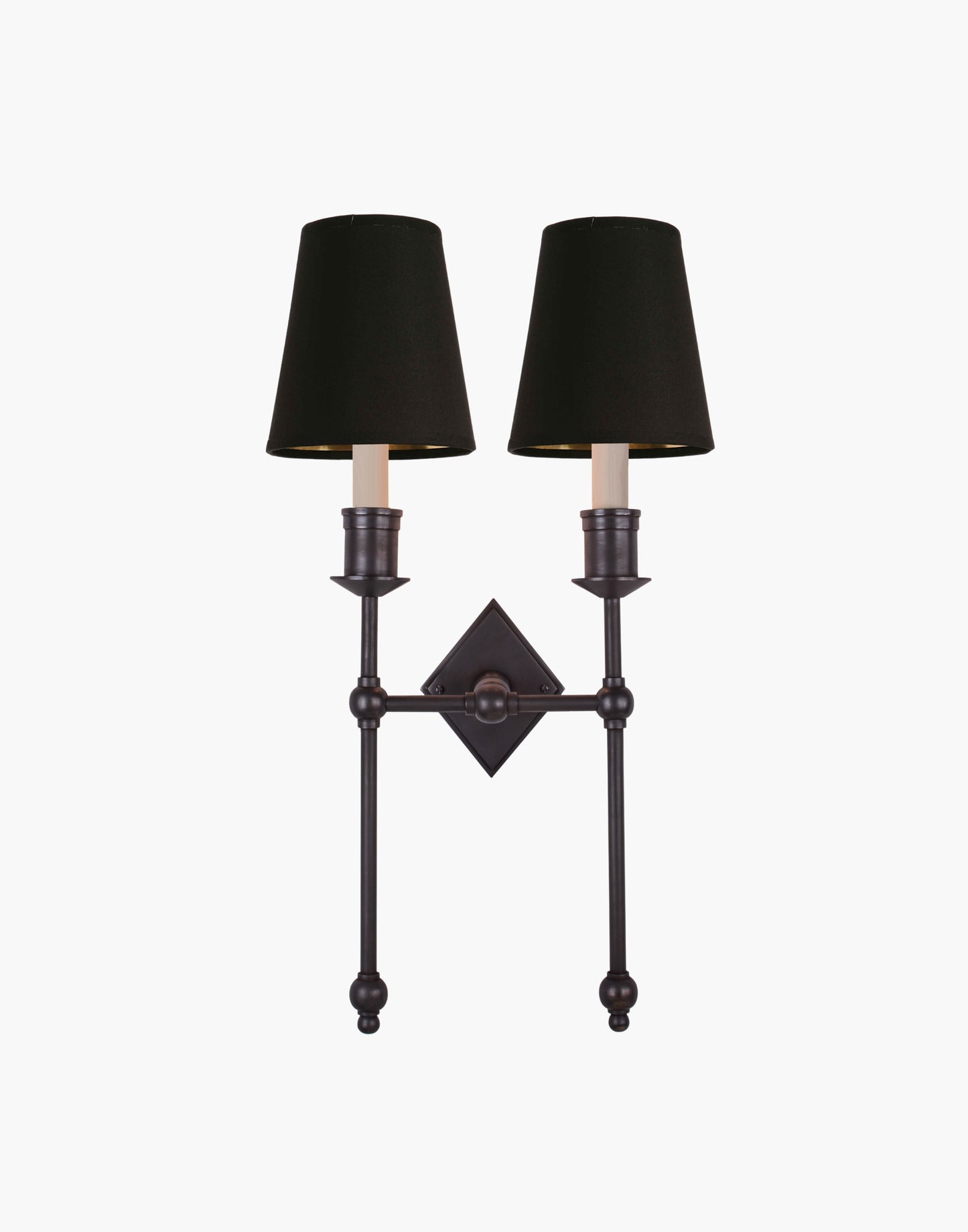 Wall sconce in cast and machined brass with diamond-shaped scalloped backplate and twin candle arms.
