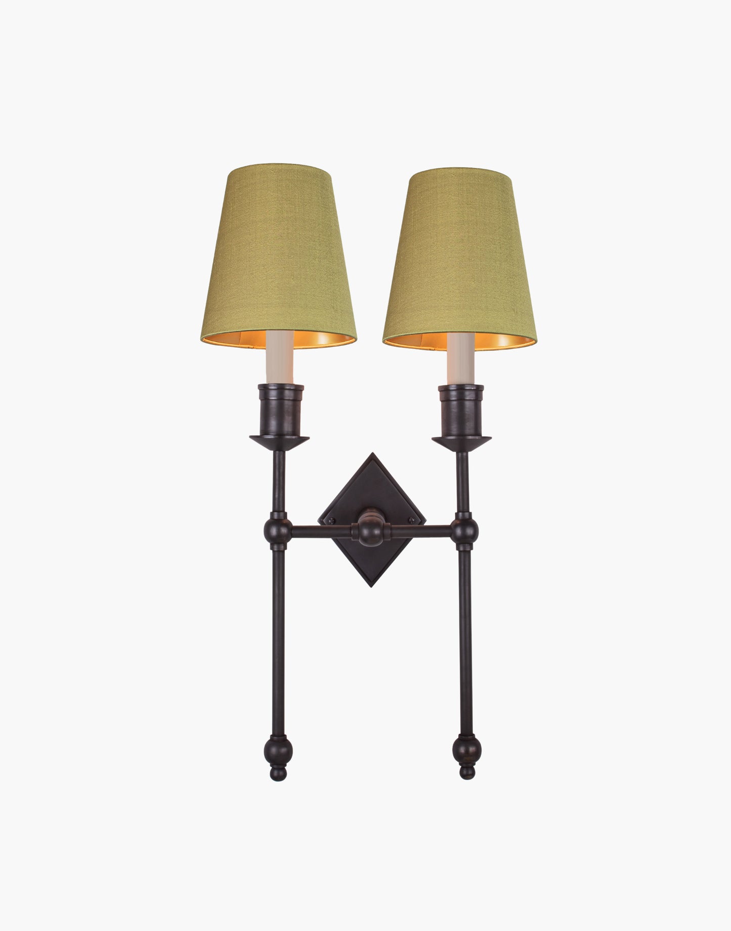 Wall sconce in cast and machined brass with diamond-shaped scalloped backplate and twin candle arms.