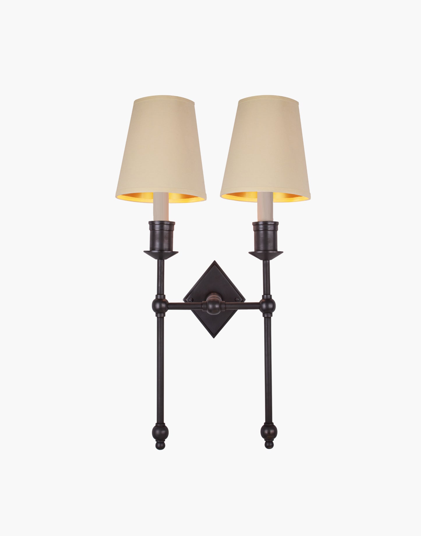 Wall sconce in cast and machined brass with diamond-shaped scalloped backplate and twin candle arms.