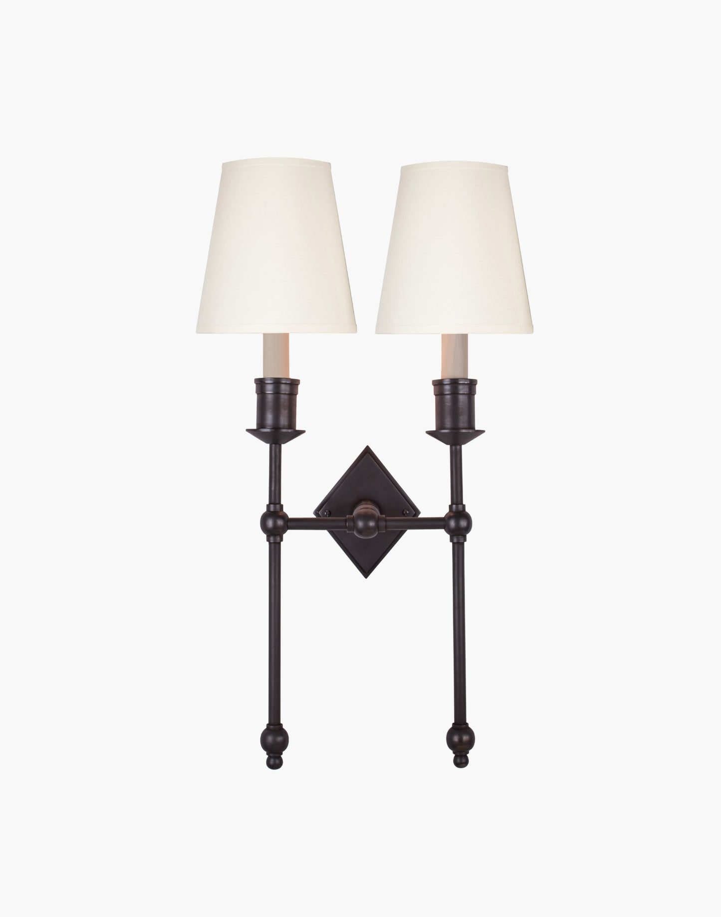 Wall sconce in cast and machined brass with diamond-shaped scalloped backplate and twin candle arms.