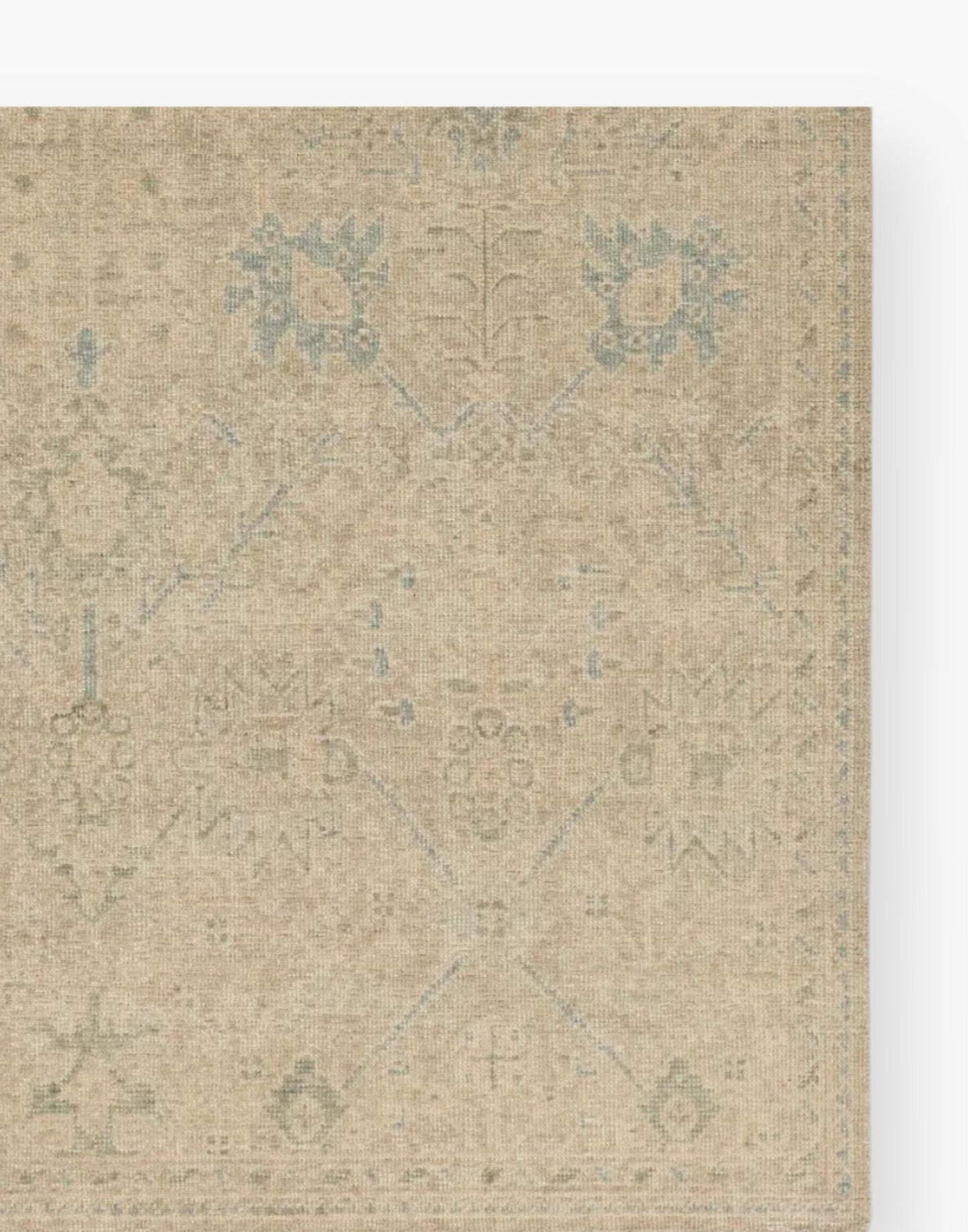 Wool rug with a distressed, floral Oushak pattern in hues of tan, blue, taupe, cream, and gray