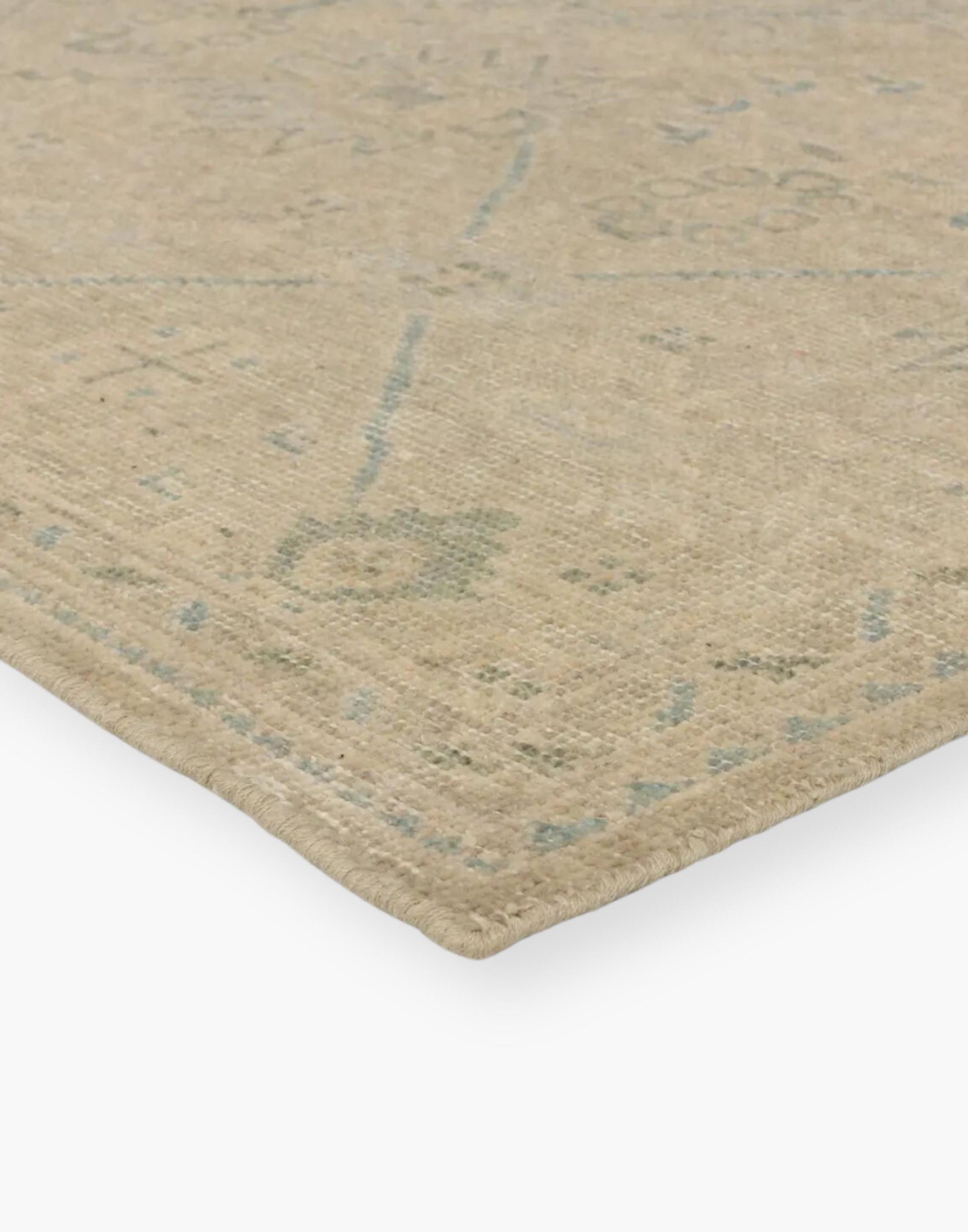 Wool rug with a distressed, floral Oushak pattern in hues of tan, blue, taupe, cream, and gray