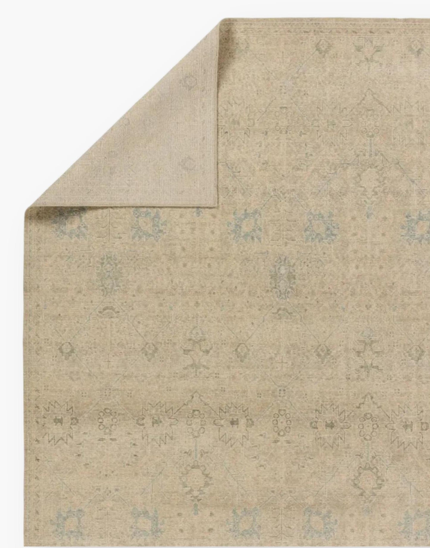Wool rug with a distressed, floral Oushak pattern in hues of tan, blue, taupe, cream, and gray