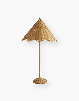 Table lamp with rattan shade and base with a large scalloped edge and a stainless steel stem finished in antique brass.