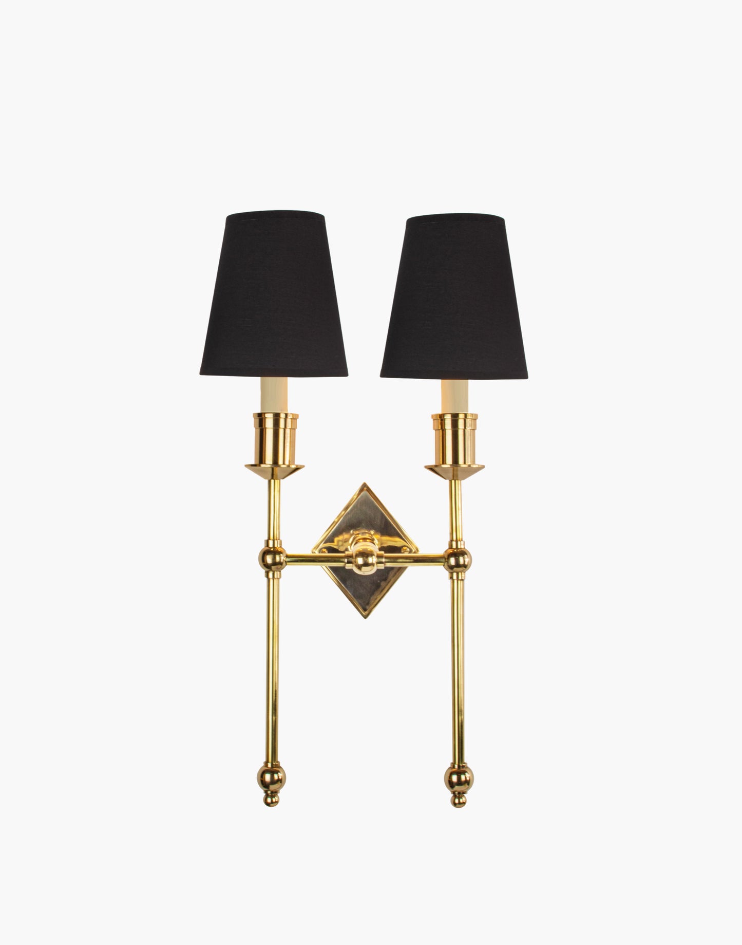 Wall sconce in cast and machined brass with diamond-shaped scalloped backplate and twin candle arms.