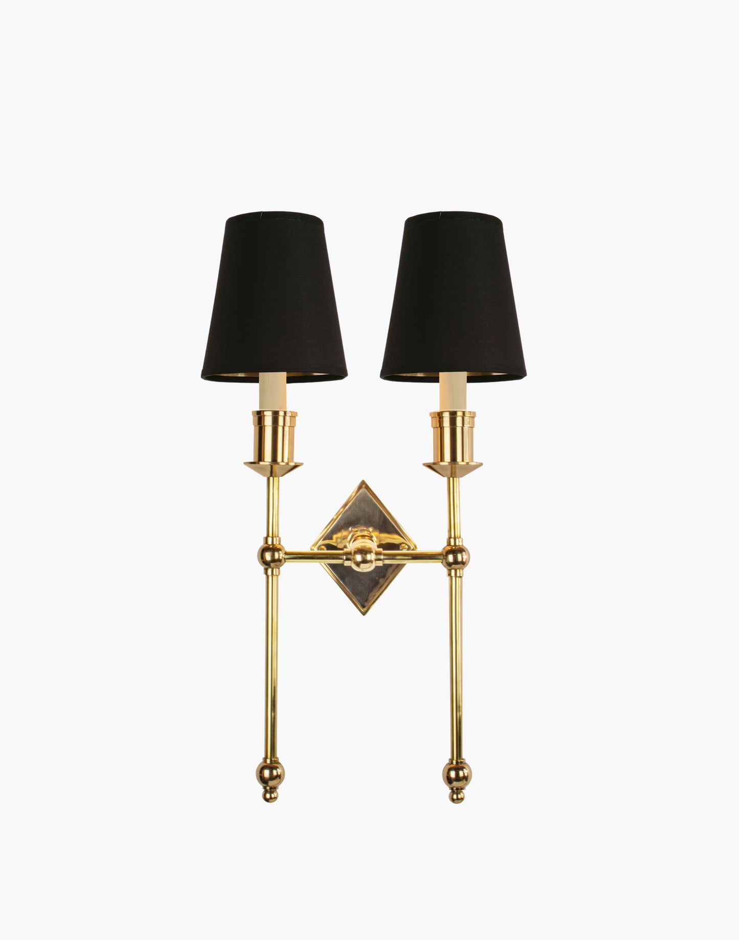 Wall sconce in cast and machined brass with diamond-shaped scalloped backplate and twin candle arms.