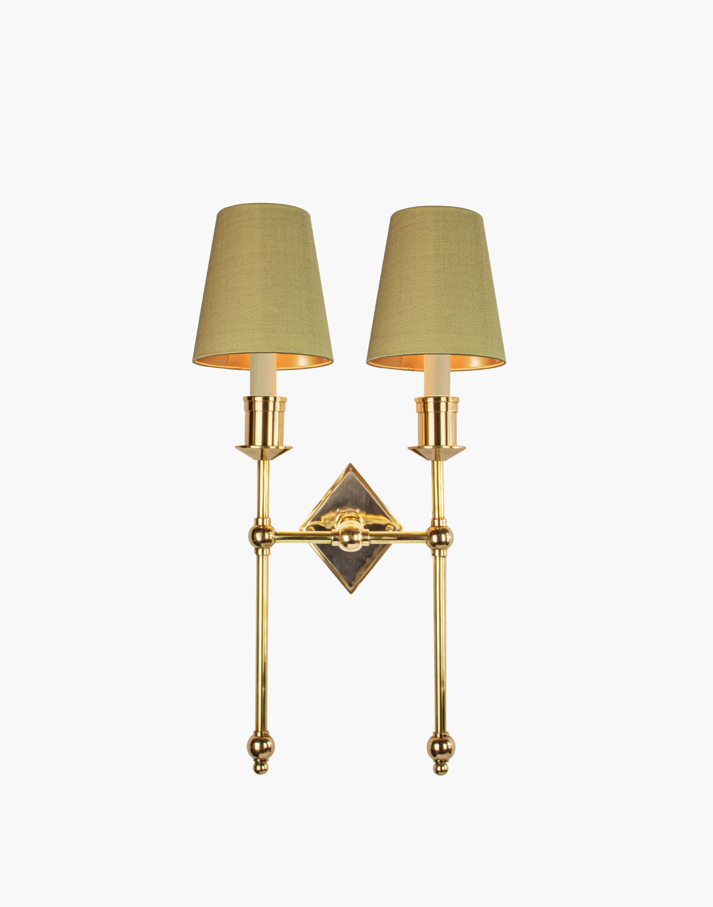 Wall sconce in cast and machined brass with diamond-shaped scalloped backplate and twin candle arms.