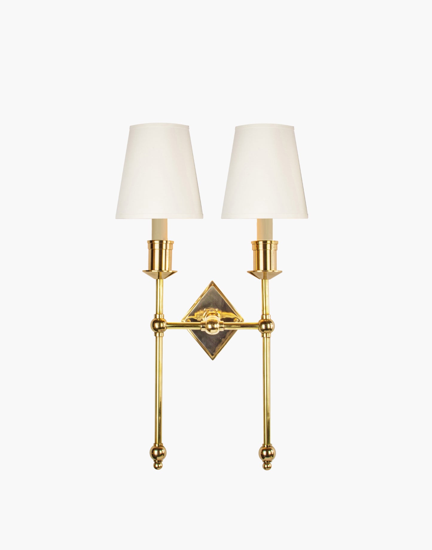Wall sconce in cast and machined brass with diamond-shaped scalloped backplate and twin candle arms.