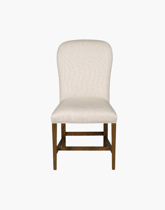 Fully upholstered gentle balloon shaped back resides over an upholstered seat with gracefully tapering legs.
