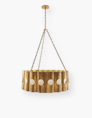 Chandelier in antique brass iron and a scalloped drum shade with circular cutouts, fitted with an off-white microfiber shade.