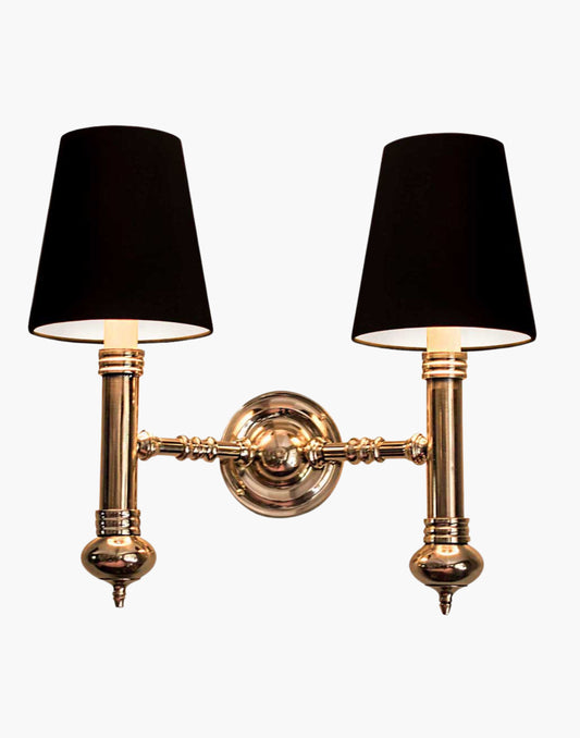 Twin Wall Sconce in cast brass, compact period-style double wall light creating warm ambient illumination.