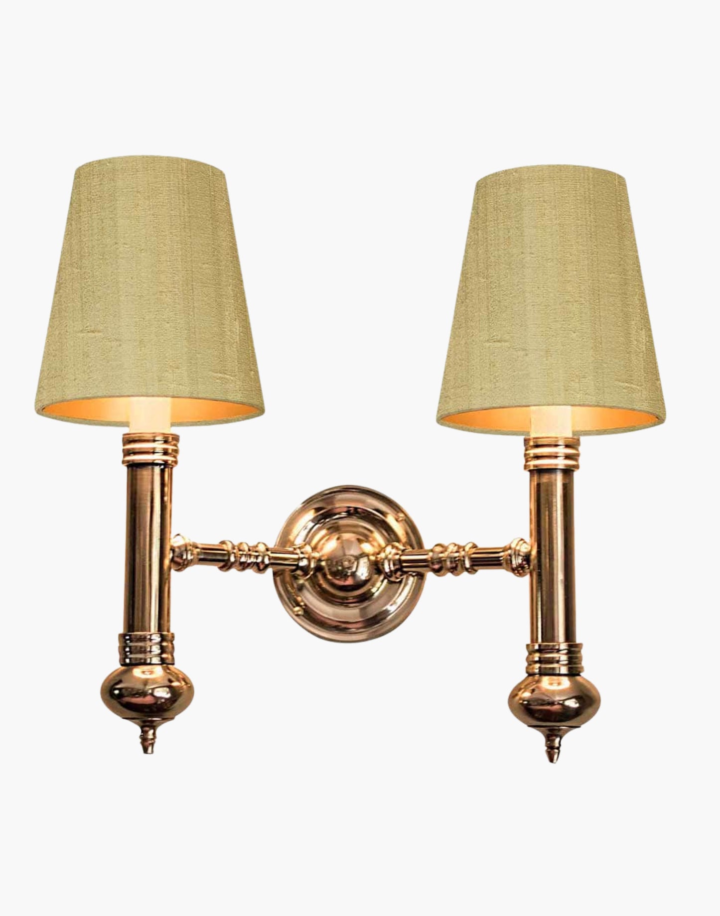 Twin Wall Sconce in cast brass, compact period-style double wall light creating warm ambient illumination.