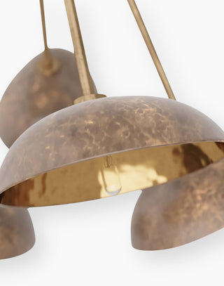Modern chandelier cast in antique brass with a cluster of pod shapes that extend from five arms with a burnished top finish with an inside hammered texture.
