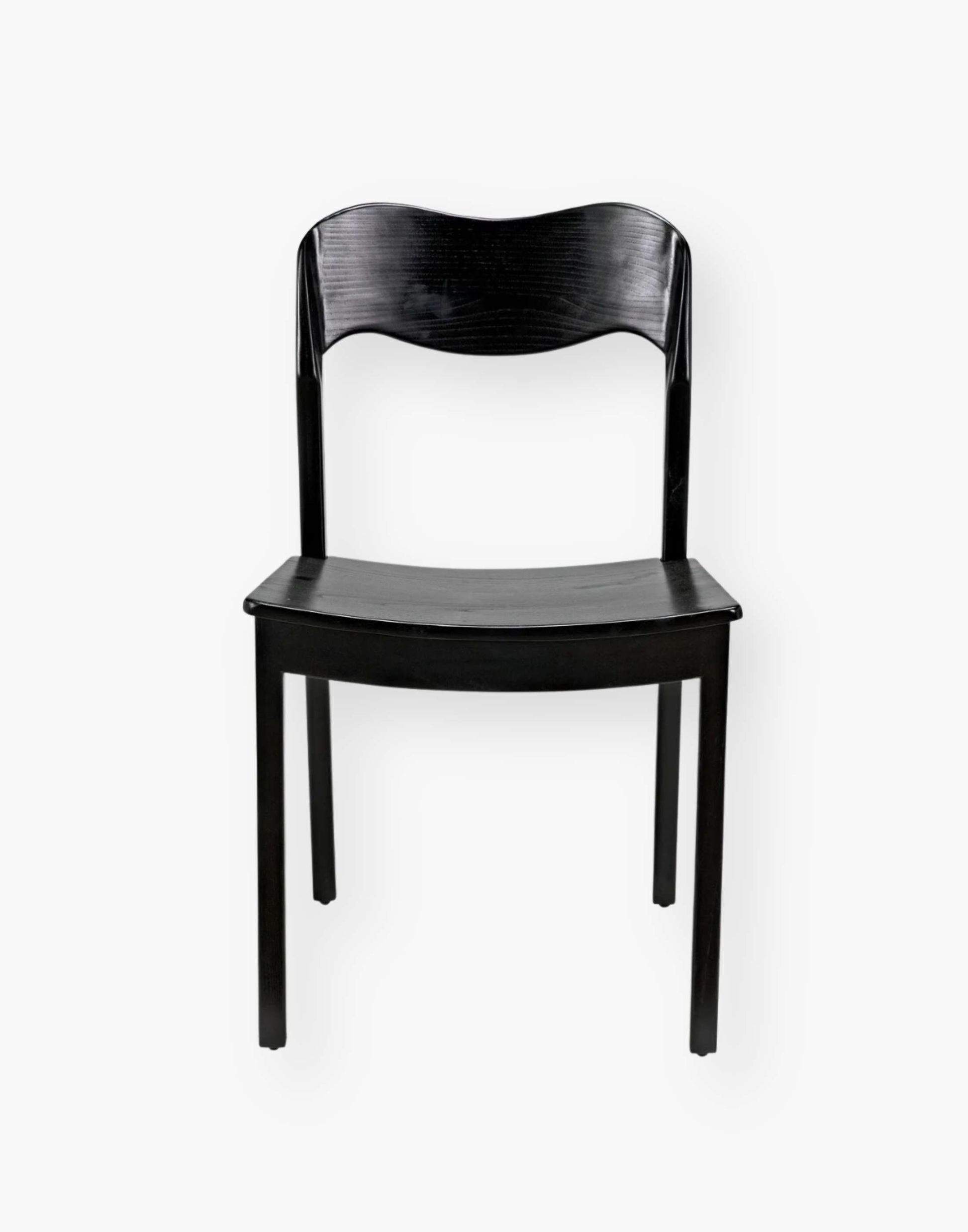 Dining chair with a subtly scalloped back and a curved seat with a black-finished sungkai wood frame.