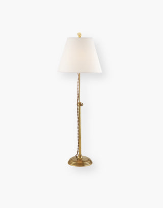 Hand-rubbed antique brass adjustable base table lamp with a linen shade.