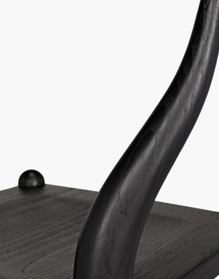 Counter stool that is hand-carved of sungkai wood with a charcoal black finish.